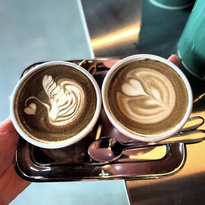 Twee cappuccino's met latte art op een dienblad